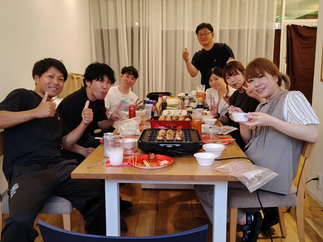 食事を囲みポーズを取る人たち